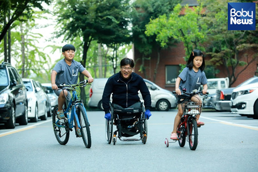 지난 9월 25일 인천시 연수구 한 아파트에서 휠체어를 탄 박대운(46) 씨와 자전거 탄 두 아이가 함께 놀이터로 향하고 있다. 최대성 기자 ⓒ베이비뉴스