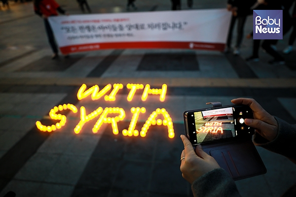 행사 관계자가 바닥에 설치된 '시리아와 함께한다는 문구(with syria)'를 핸드폰 카메라로 찍고 있다. 최대성 기자 ⓒ베이비뉴스