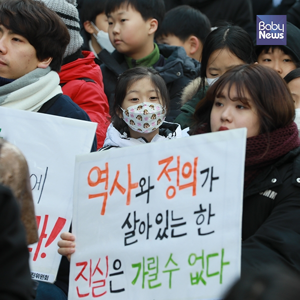 23일 오후 서울 종로구 옛 일본대사관 앞에서 제1371회 일본군성노예제 문제 해결을 위한 정기수요시위가 열렸다. 피켓 뒤 한 소녀의 눈빛이 또렷하다. 최대성 기자 ⓒ베이비뉴스