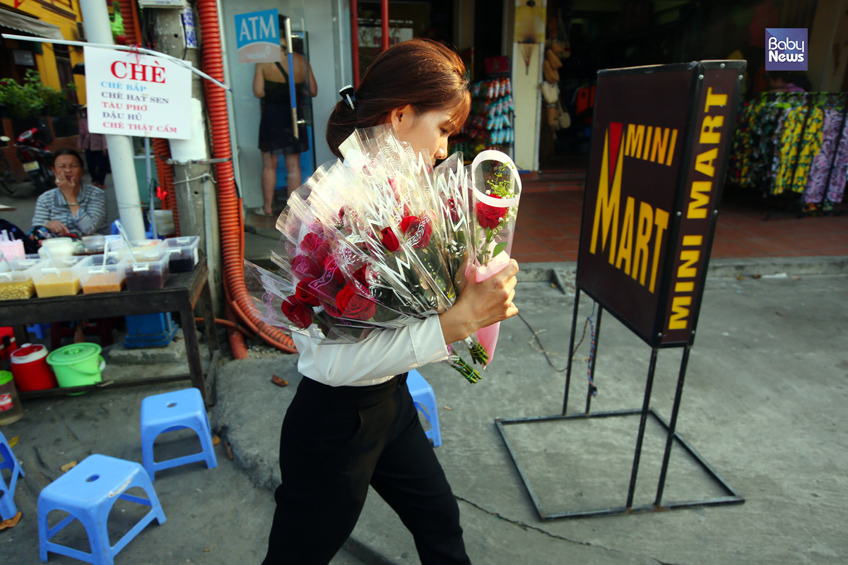 하노이 인근 카페의 직원으로 보이는 한 여성이 많은 양의 꽃을 들고 걸어가고 있다. 카페에 오는 여성들에게 선물하려는 꽃들로 보인다. 김재호 기자 ⓒ베이비뉴스