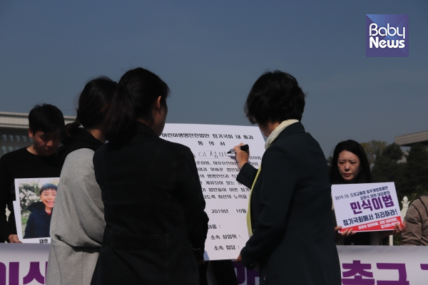 지난달 21일 서울 영등포구 국회의사당 정문 앞에서 정치하는엄마들 주최로 열린 어린이생명안전법 촉구 기자회견에서 이정미 정의당 의원이 어린이생명안전법 동의서에 서명하고 있는 모습.이중삼 기자ⓒ베이비뉴스