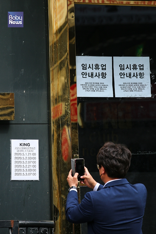 확진자가 무더기로 발생한 서울 용산구 이태원 킹클럽에서 한 시민이 휴대폰으로 방역시간이 적혀있는 안내문을 촬영하고 있다. 서종민 기자 ⓒ베이비뉴스