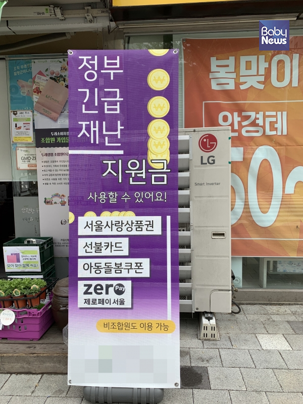 서울의 한 생활협동조합 앞에 아동돌봄쿠폰 이용이 가능하다는 입간판이 세워져 있다. 김정아 기자 ⓒ베이비뉴스