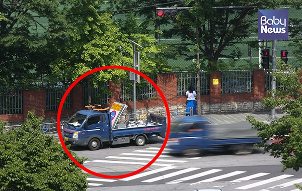 16일 오전 서울 용원 초등학교 앞 스쿨존에서 어린이보호구역 표지판을 실은 작업차량이 10분 이상 정차하고 있다. 운전자 시야를 가리는 불법 주정차는 교통사고의 주요 원인으로 스쿨존에서는 어떠한 형태로든 불허된다. 최대성 기자 ⓒ베이비뉴스