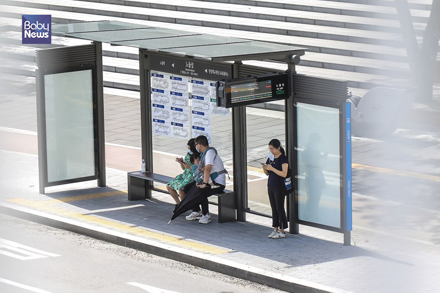 31일 오후 서울의 한 버스정류장에서 버스를 기다리는 부부 옆에 시민이 마스크를 잠시 벗고 있다. 김재호 기자 ⓒ베이비뉴스