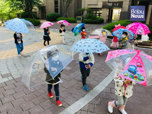 수상작품 중 하나인 서울 우애들어린이집 만 2세반 산책 모습. 우산을 쓰고 산책함으로써 자연스럽게 거리두기가 가능해졌다. ⓒ전국국공립어린이집연합회