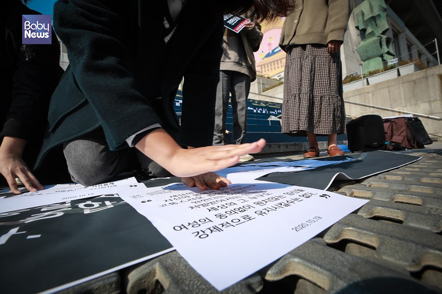 모자보건법 개정에 반대하는 시민 의견서를 개정안이 적혀있는 현수막에 부착하고 있다.김재호 기자 ⓒ베이비뉴스