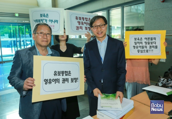 임재택 당시 유아교육보육혁신연대 상임대표(왼쪽)와 관계자들이 2017년 6월 21일 오전 서울 종로구 국정기획자문위원회에서 김성주 당시 국정기획자문위원회 자문단장에게 유보통합 국정과제 성명지를 전달하고 있다. ⓒ베이비뉴스