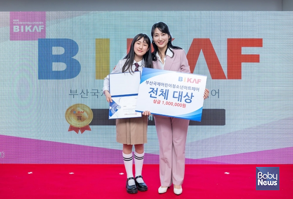 이영애 사단법인 비카프 이사장이 문서인 작가에게 제6회 부산국제어린이청소년아트페어 미술공모전 대상을 수여한 뒤 기념촬영을 하고 있다. 소장섭 기자 ⓒ베이비뉴스